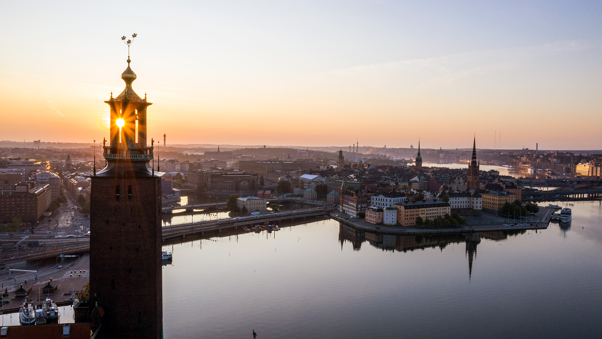 Kvällsskymning med vy över Stockholms stadshus och vattnet.